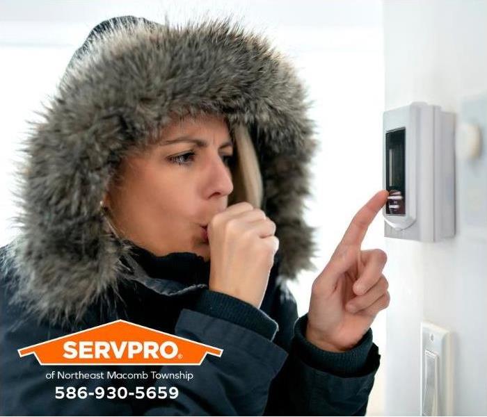 A person raises the thermostat to prevent the pipes from freezing.