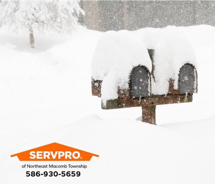 Mailboxes in front of homes are almost submerged in heavy snow.